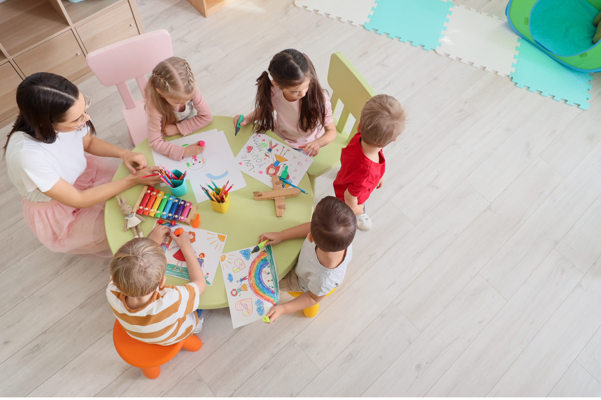 nursery teacher drawing with children